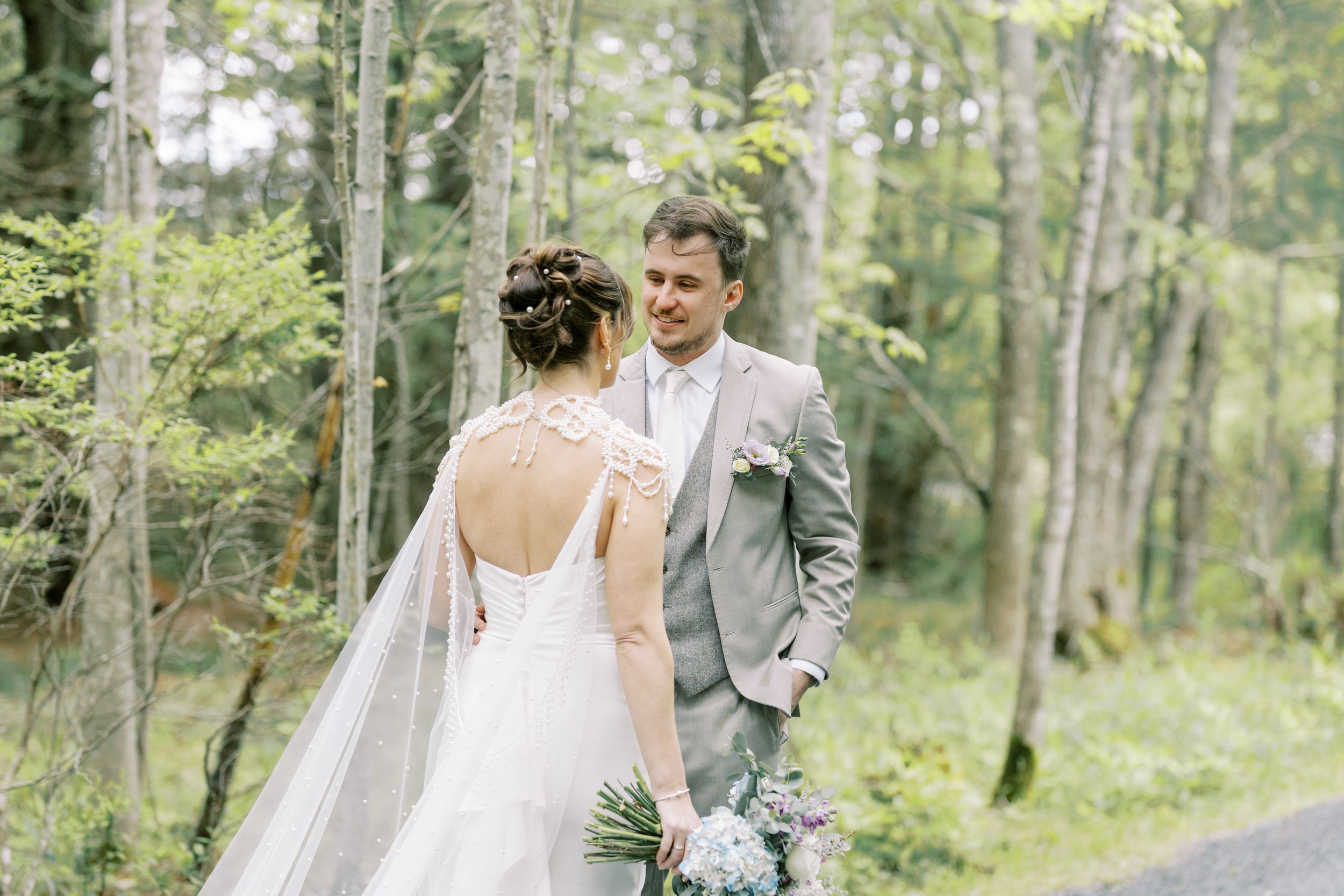 A couple shares an intimate moment in a dreamy birch forest setting during their wedding celebration.
