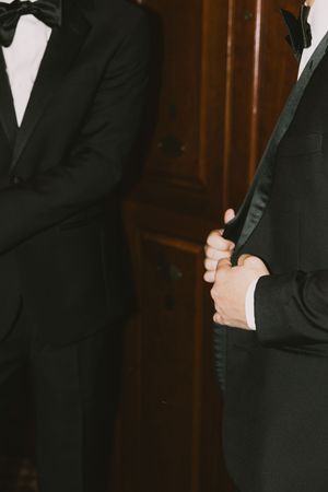 Detail shot of formal black tuxedos in classic wedding attire.