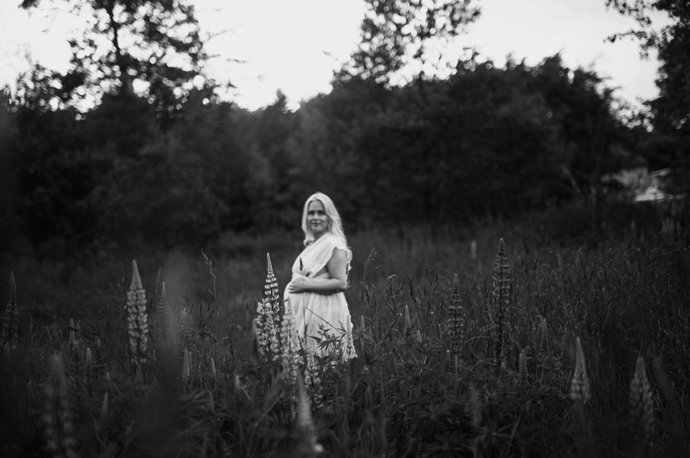 Scenic forest path captured in silhouette style with moody black and white tones and vertical orientation.