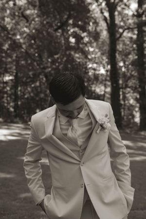 A black and white portrait of groomsmen in light colored formal suits.