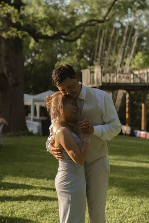 A couple shares their first dance on the lawn during their outdoor wedding reception.
