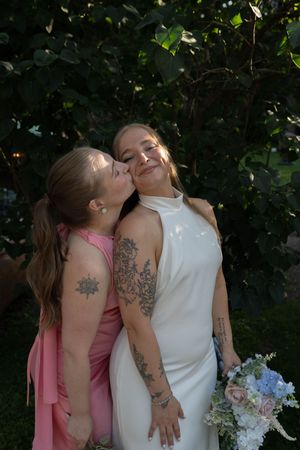 Intimate wedding moment captured among green foliage with soft natural lighting.