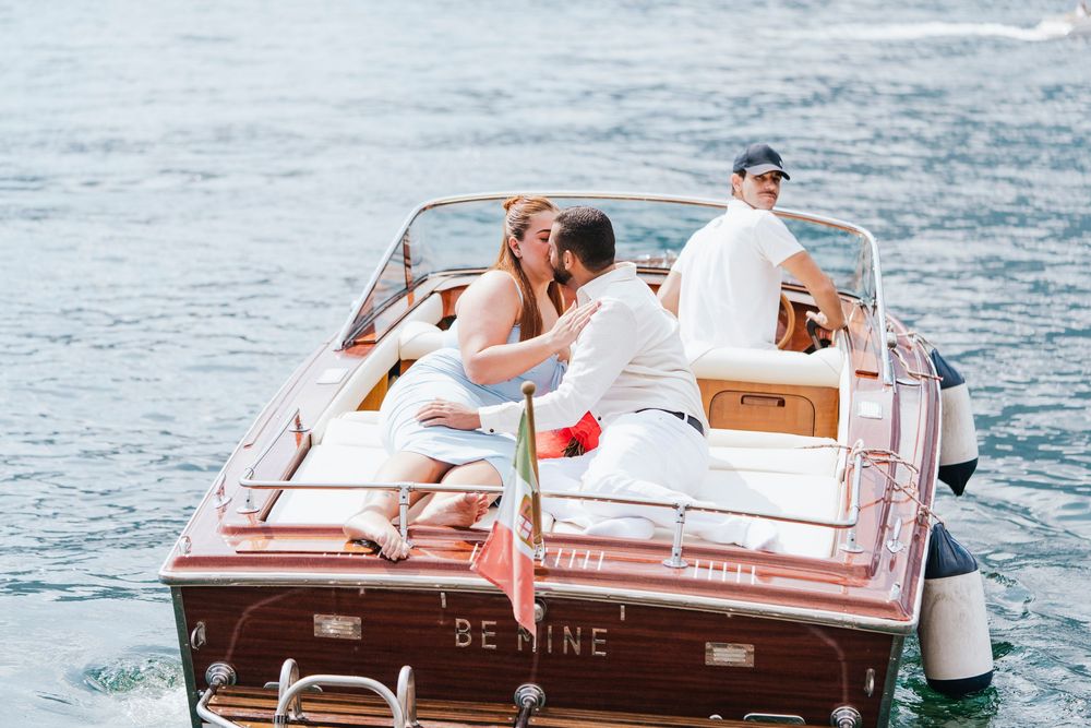 People enjoying a sunny day on a vintage wooden boat cruising across blue waters.
