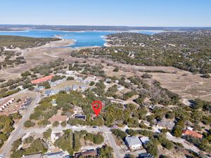Aerial view of a residential neighborhood near Canyon Lake, Texas, with a large reservoir visible in the background.