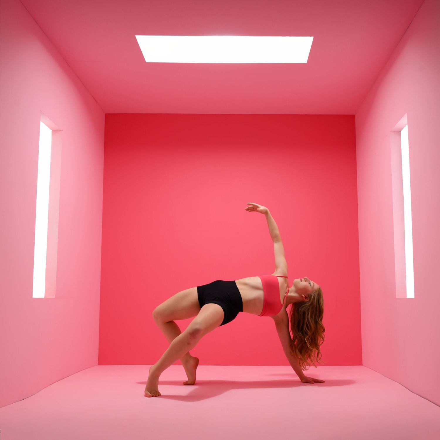 Contemporary dance poses performed in pink-hued minimalist studio setting.