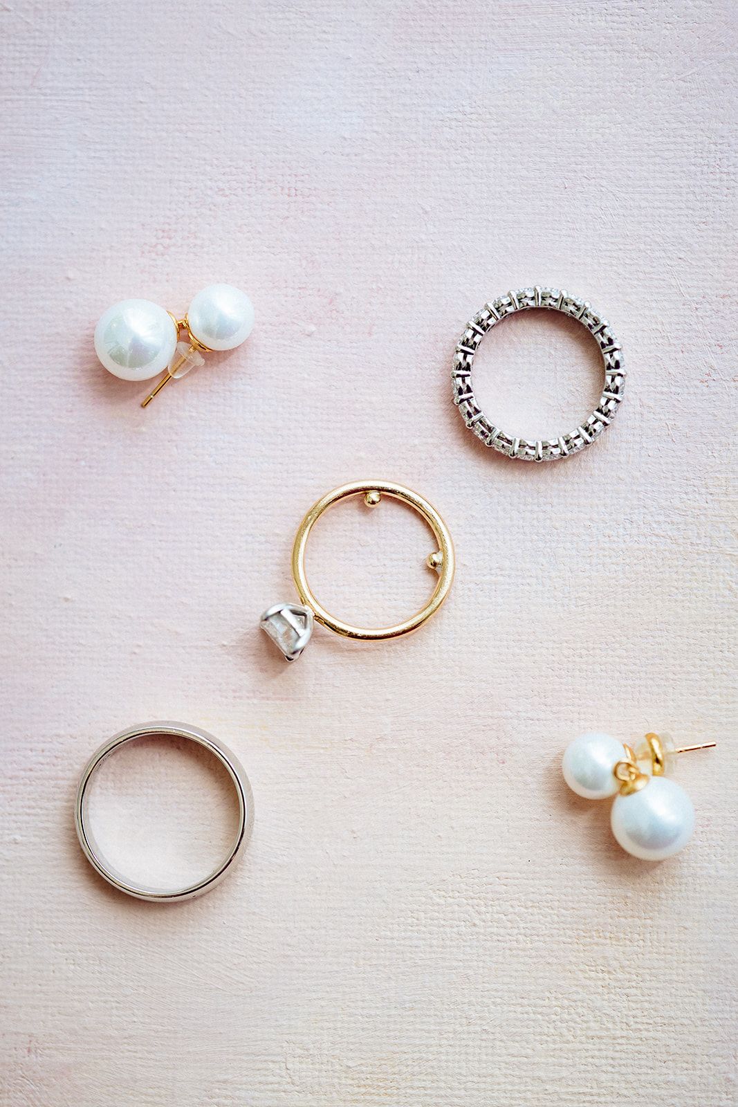Tutorial showing step by step process of making a minimalist pearl and metal ring on white fabric background.