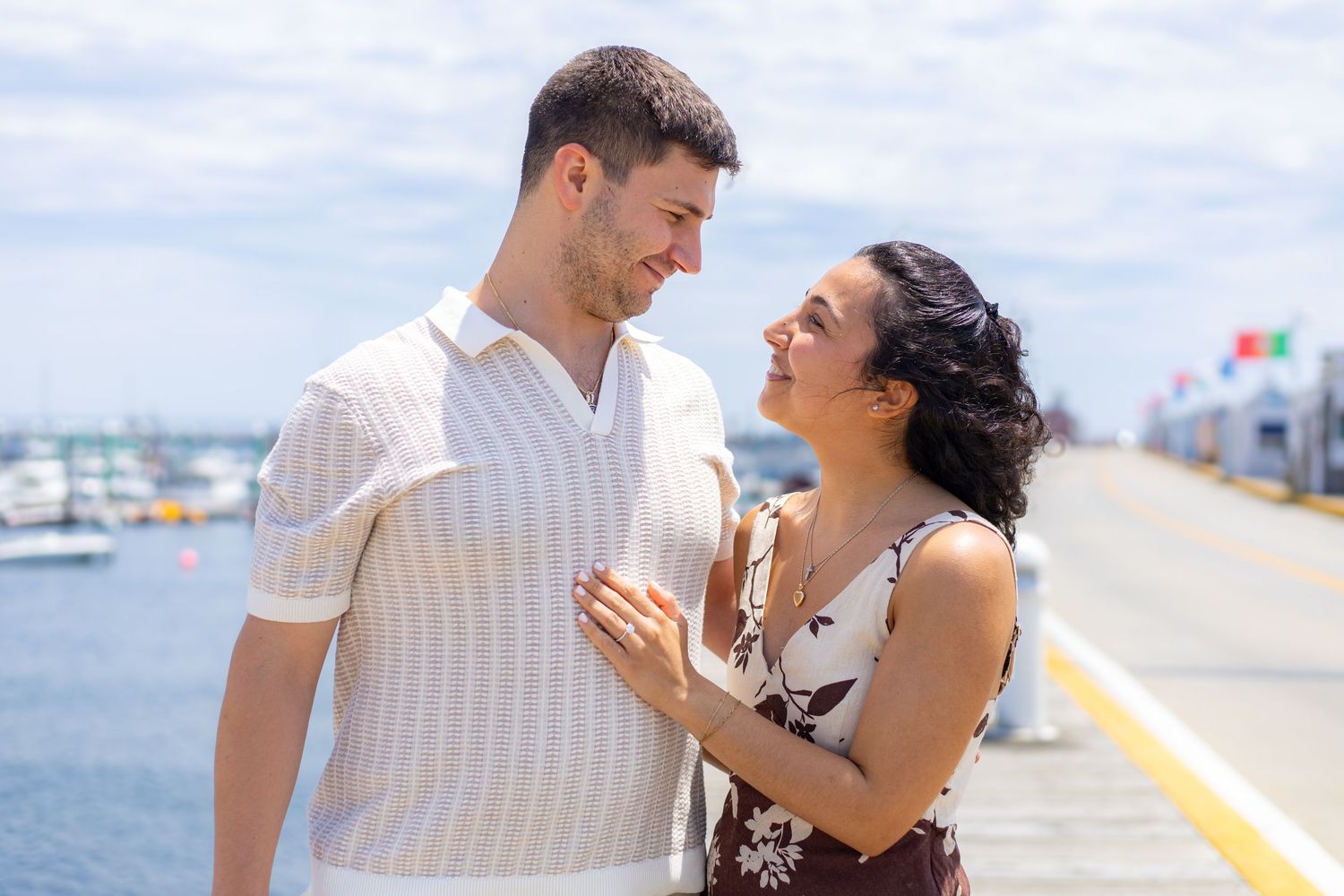 Couple walking along a serene beach shoreline at sunset wearing formal attire.