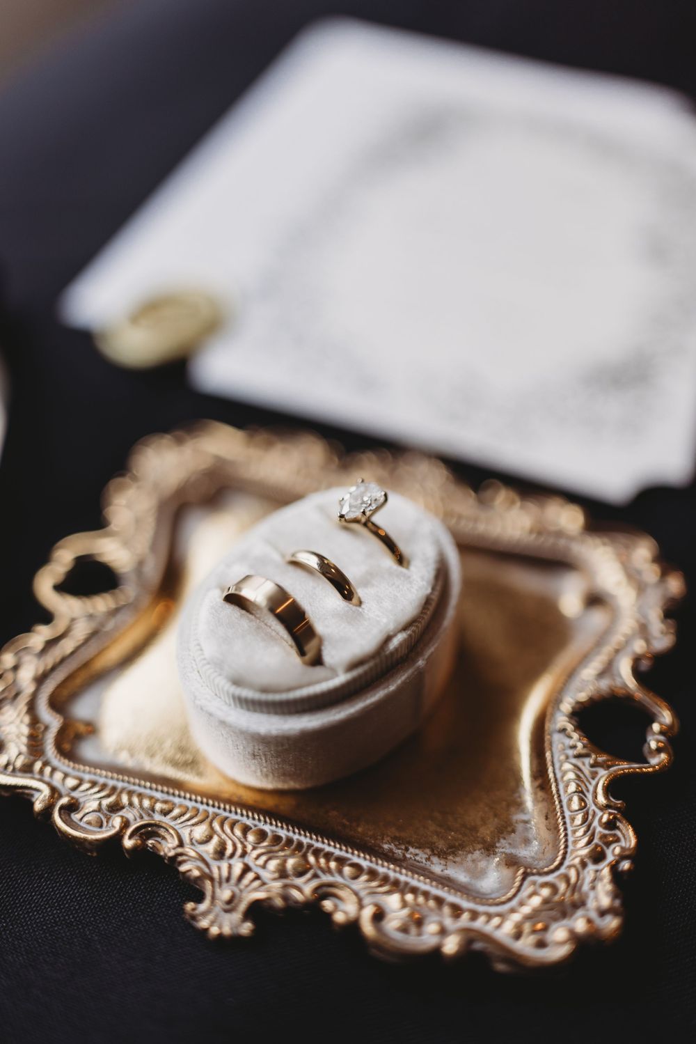 A series of close-up shots showing wedding rings on an ornate gold vintage frame against a dark background.