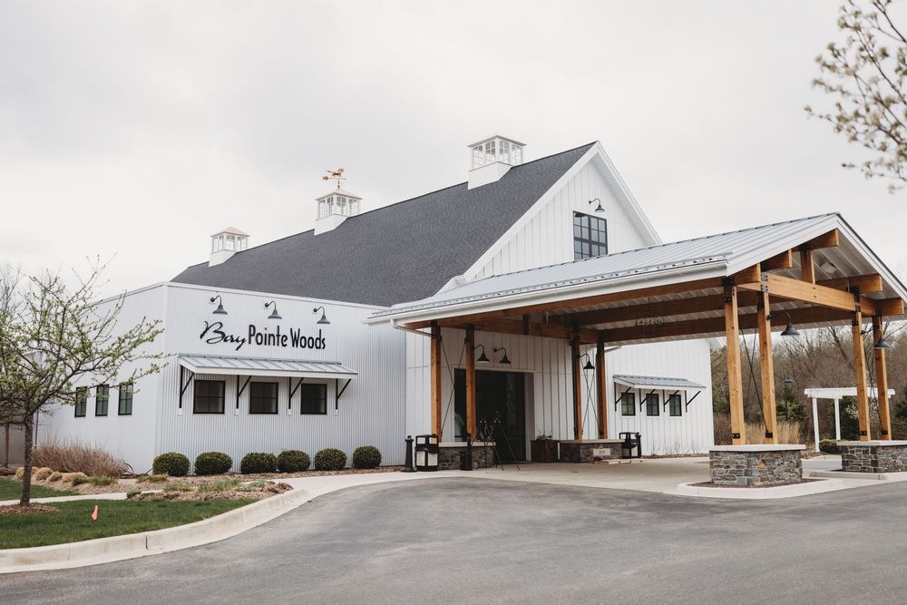 Modern white barn wedding venue with covered porch and elegant entrance designed for rustic countryside ceremonies.