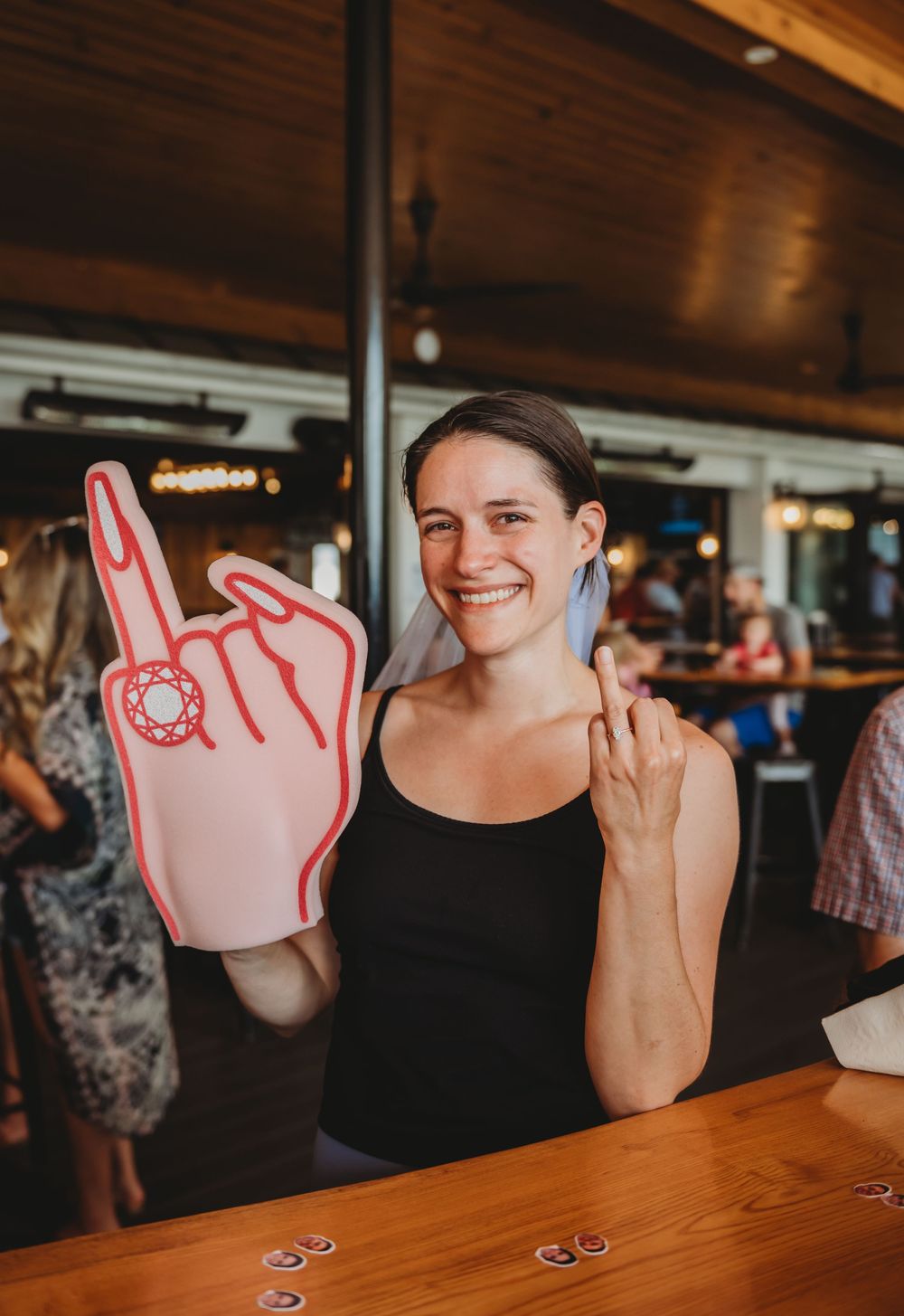 A sequence of photos showing someone with an Olympic-themed foam finger sitting at a wooden bar.