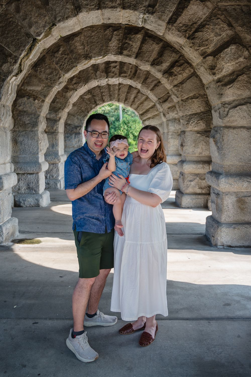A family laughs joyfully together under stone archways in a series of candid family photos.
