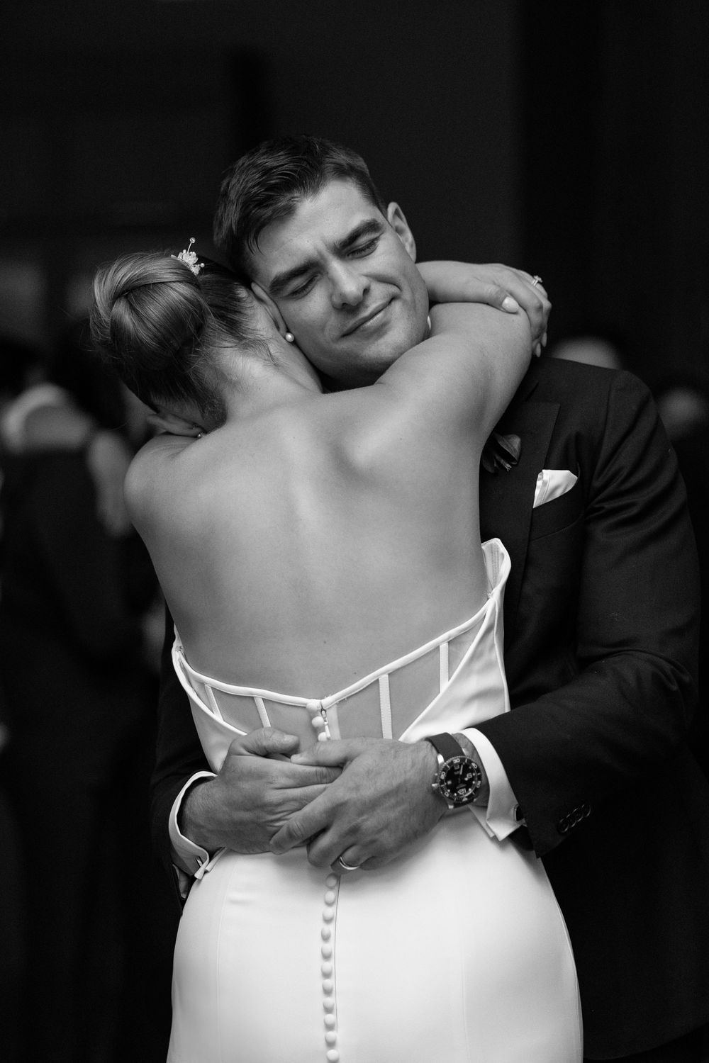 A series of black and white wedding photos showing intimate embraces between a couple in formal attire.