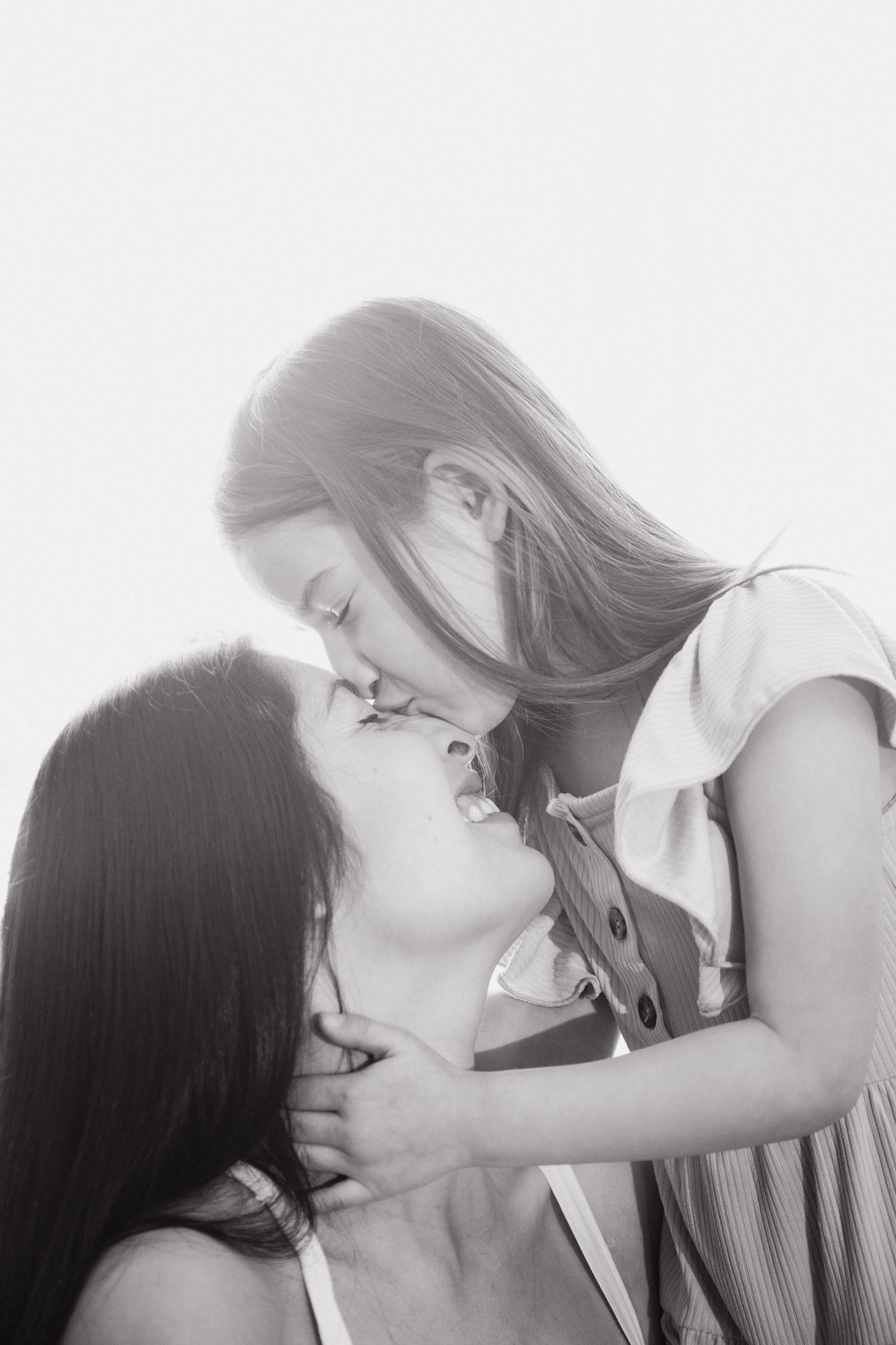 Black and white photo sequence showing a couple sharing a romantic kiss in four progressive frames.