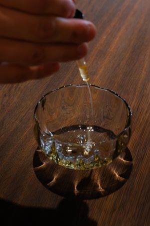 A cut glass dish catching light and casting shadows on a dark wooden surface.