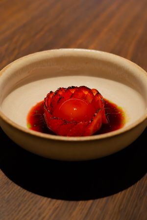 Multiple shots show a sliced strawberry garnish placed artfully on a white plate with dark sauce decoration.