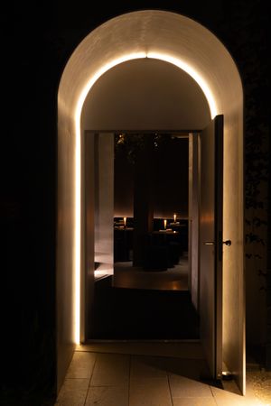 Dimly lit arched hallway with dramatic architectural lighting creating a tunnel effect.