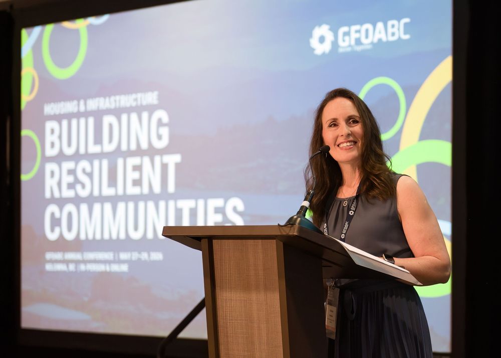 Woman speaking at GFOABC Building Resilient Communities housing and infrastructure annual conference podium.