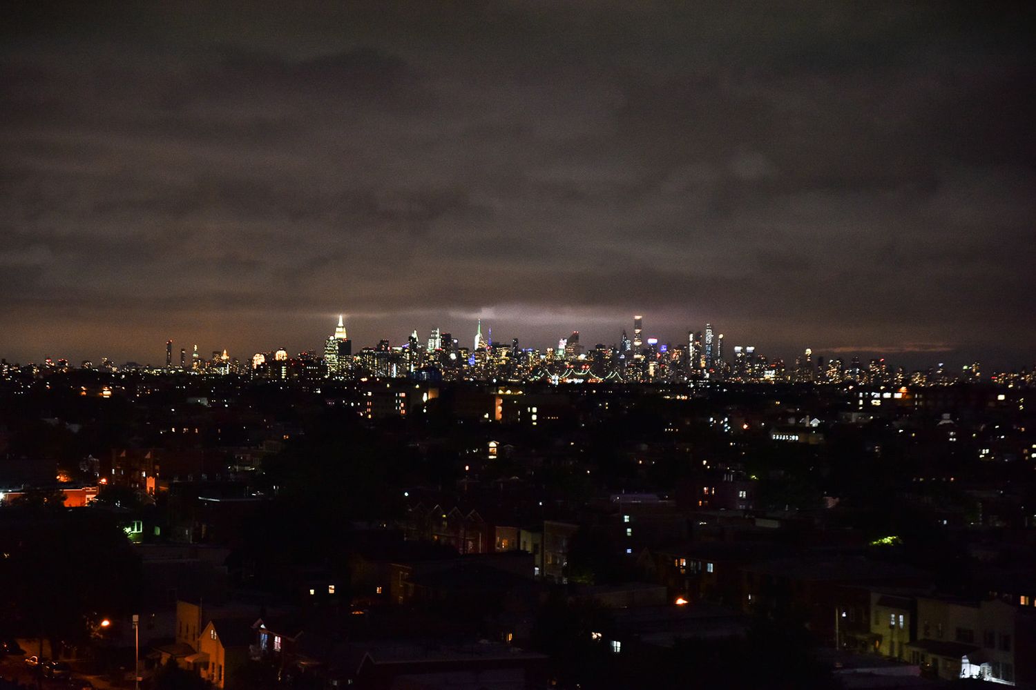Manhattan skyline glows at night from terrace on the park