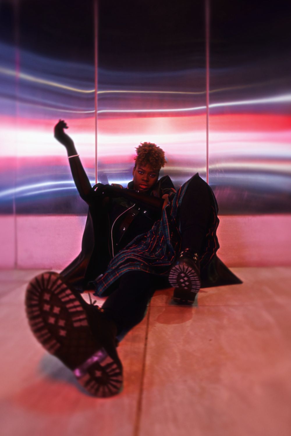 A sequence of someone falling down onto a pink and purple illuminated surface, shown in dramatic lighting.