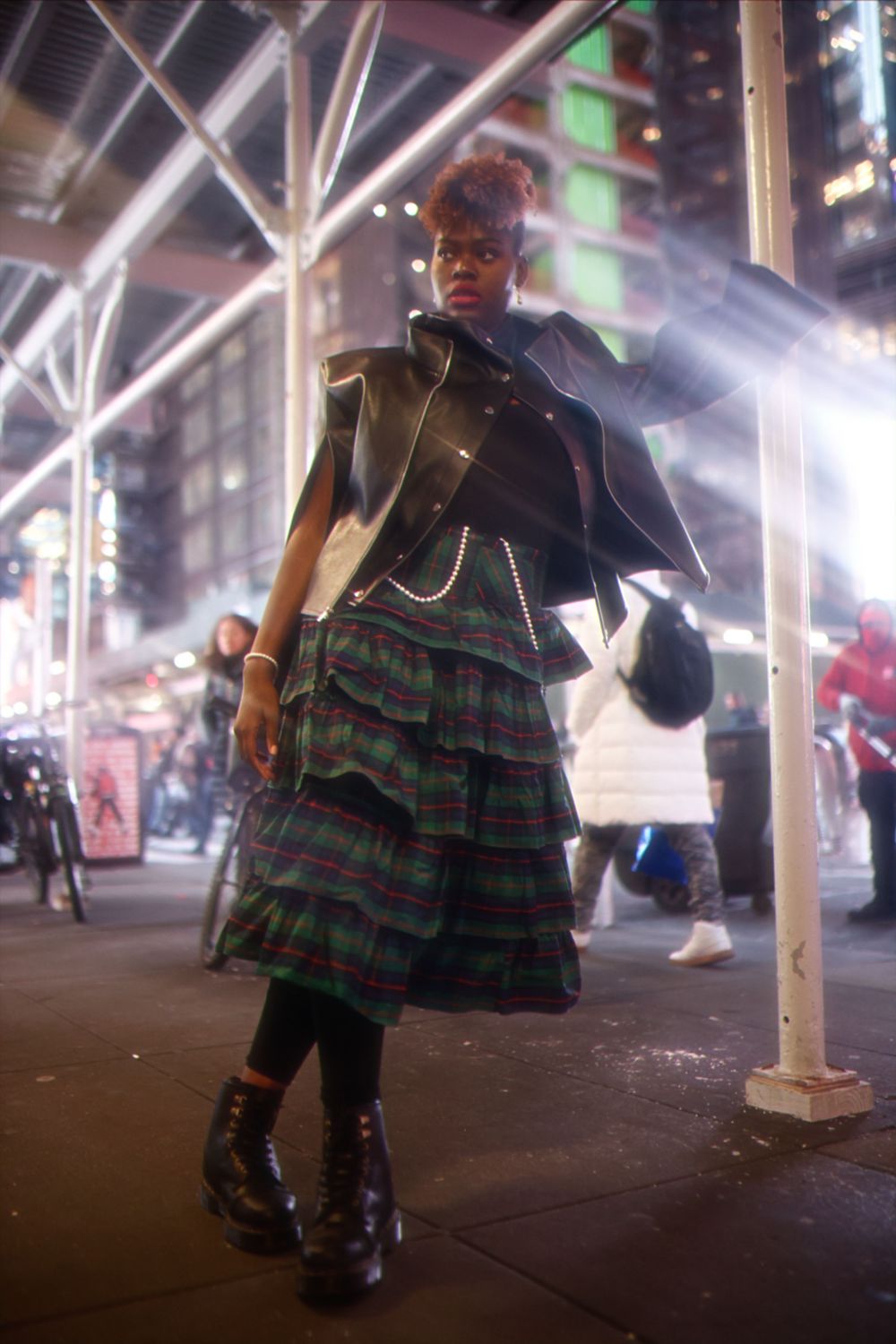 Low-angle sequence photos show a small child wearing a plaid dress and black shoes walking under urban street lights at night.