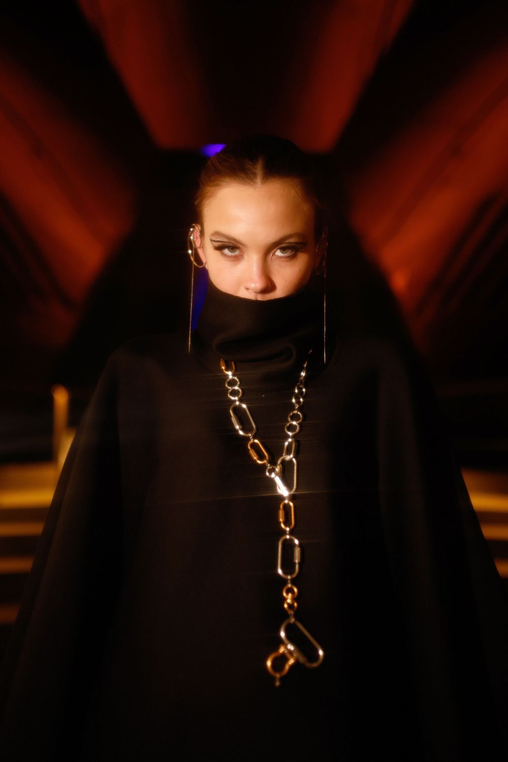 Dramatic fashion photograph series showing a person wearing black clothing and gold jewelry in moody lighting.
