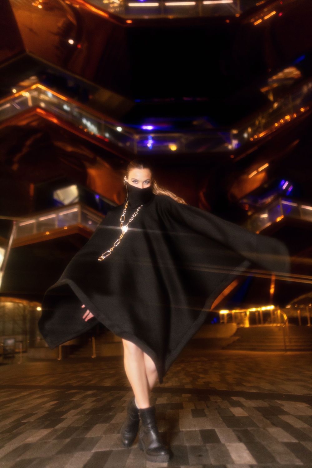 Dynamic sequence of a dancer performing fluid movements in black clothing on a dark stage with dramatic lighting.