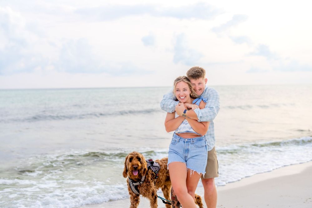 People enjoying a relaxing day at the beach with their golden retriever dog walking along the shoreline.