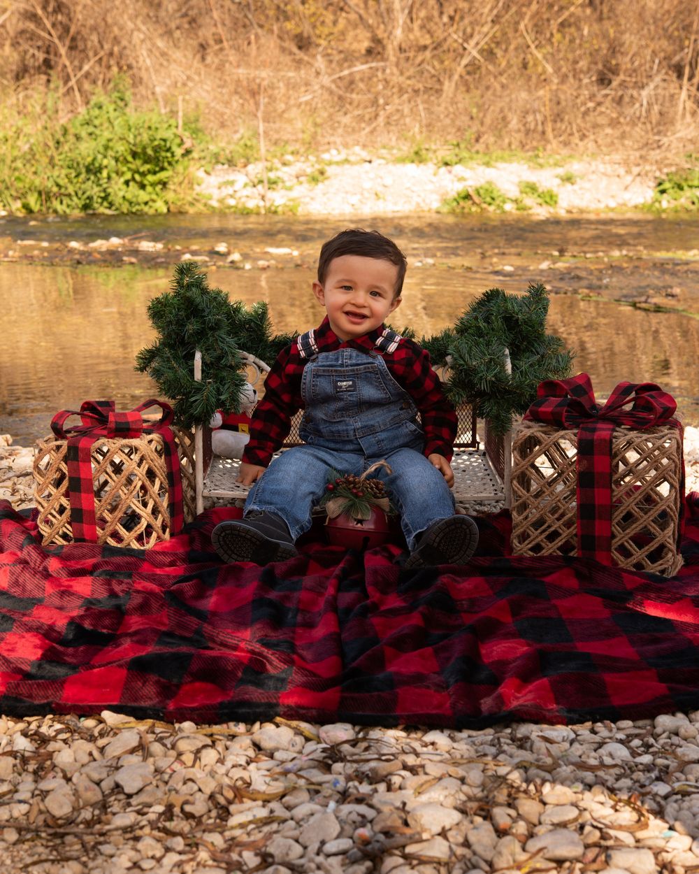 A creative photo series showing a baby resting on a buffalo plaid blanket against a rustic stone wall background.