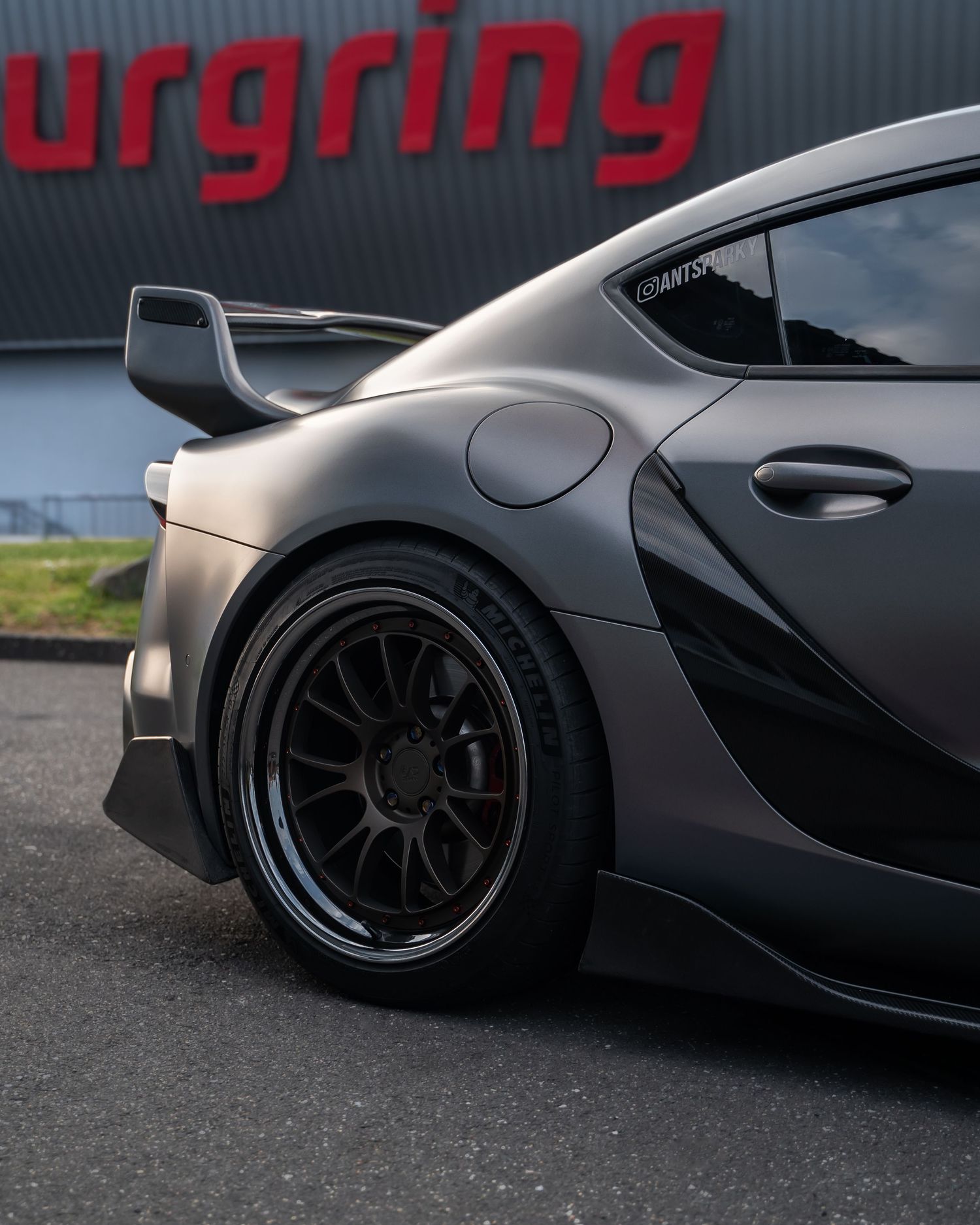 Close-up details of black modified sports cars showing custom wheels and bodywork.