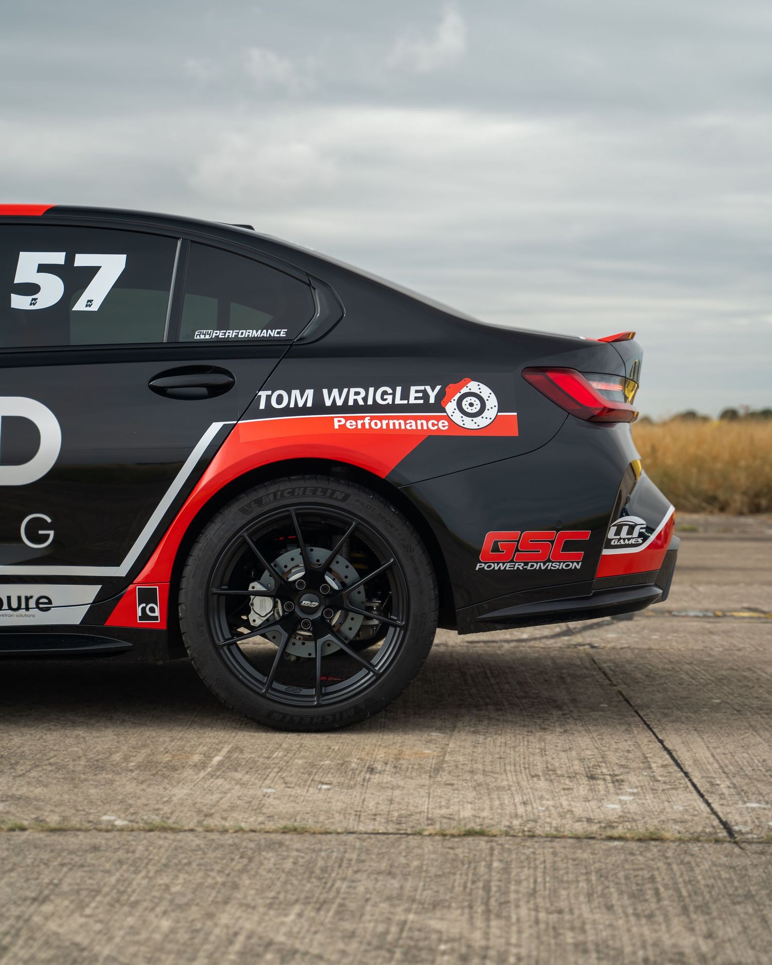 Side profile of a black racing car with red accents and racing number graphics.