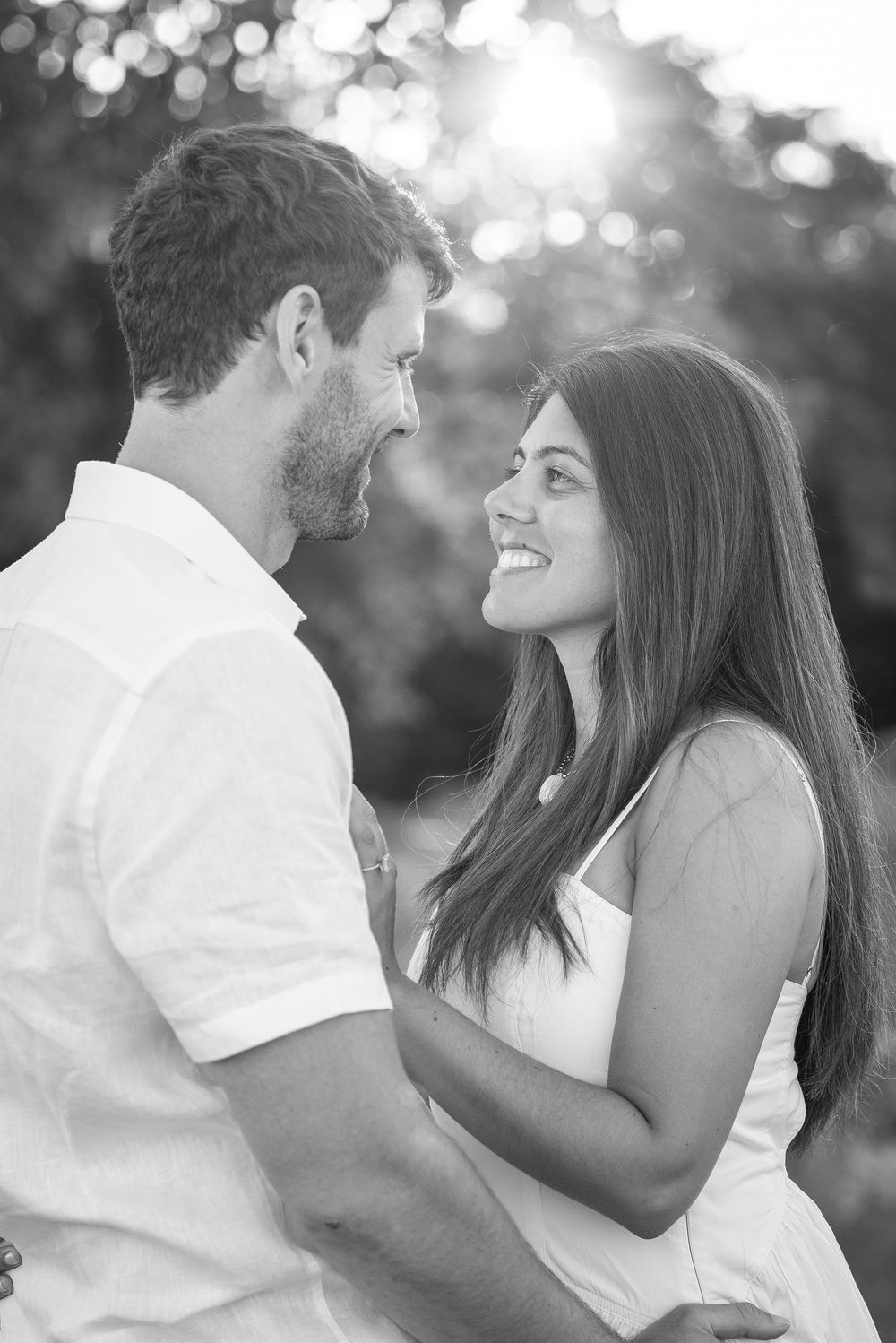 Black and white portrait of couple sharing romantic moment in outdoor setting.