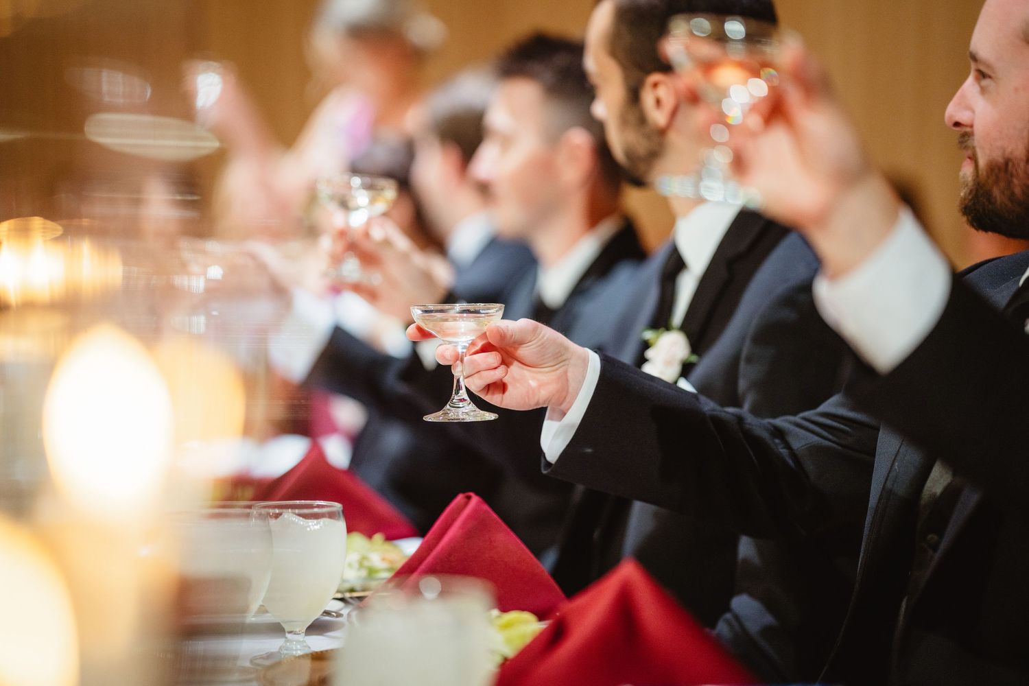 Diners dressed in formal attire enjoy a meal at an elegant candlelit table during a special occasion dinner.