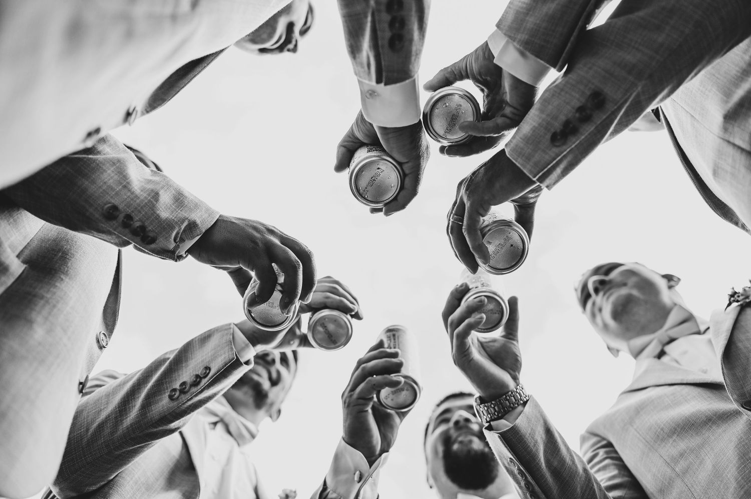 black and white photo of the groomsmen toasting before the wedding at whispering oaks wedding venue