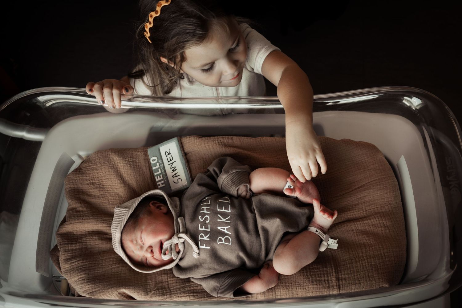 Documentary-style hospital photo from Fresh 48 session of sister meeting baby brother at Oschner Baptist in New Orleans