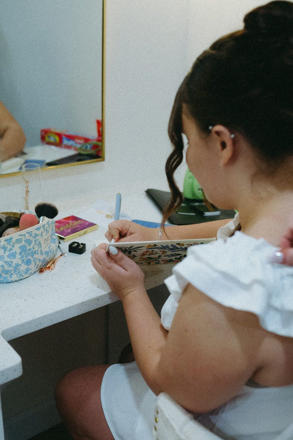 A filmy photo of a bride writing down her vows on her wedding morning