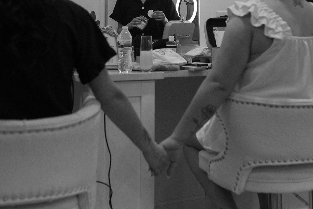 Bride and sister holding hands while getting ready on north georgia wedding day