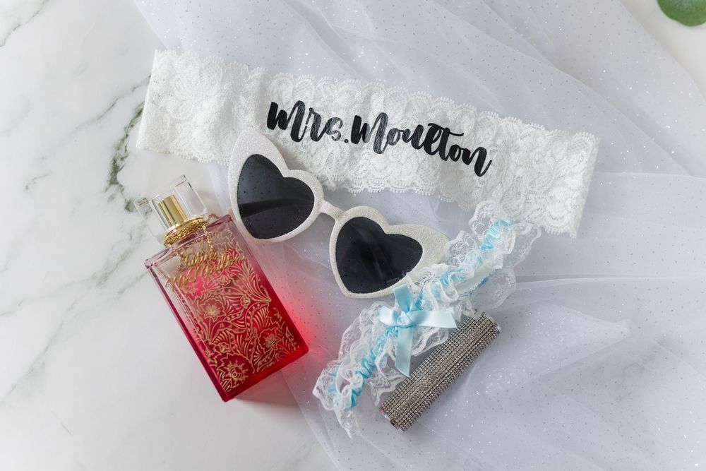 Wedding favor packaging with a heart shape and sparkly holographic glitter on a white marble surface.