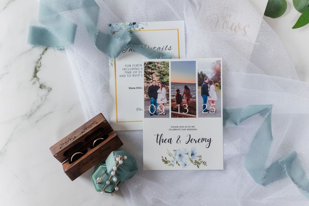Light blue ribbon and delicate wedding favors displayed with photo memories on a white marble background.