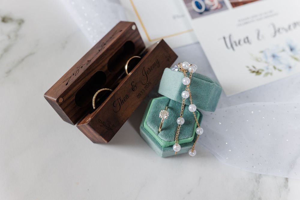 Turquoise jewelry box with pearl accessories arranged on a white marble surface.