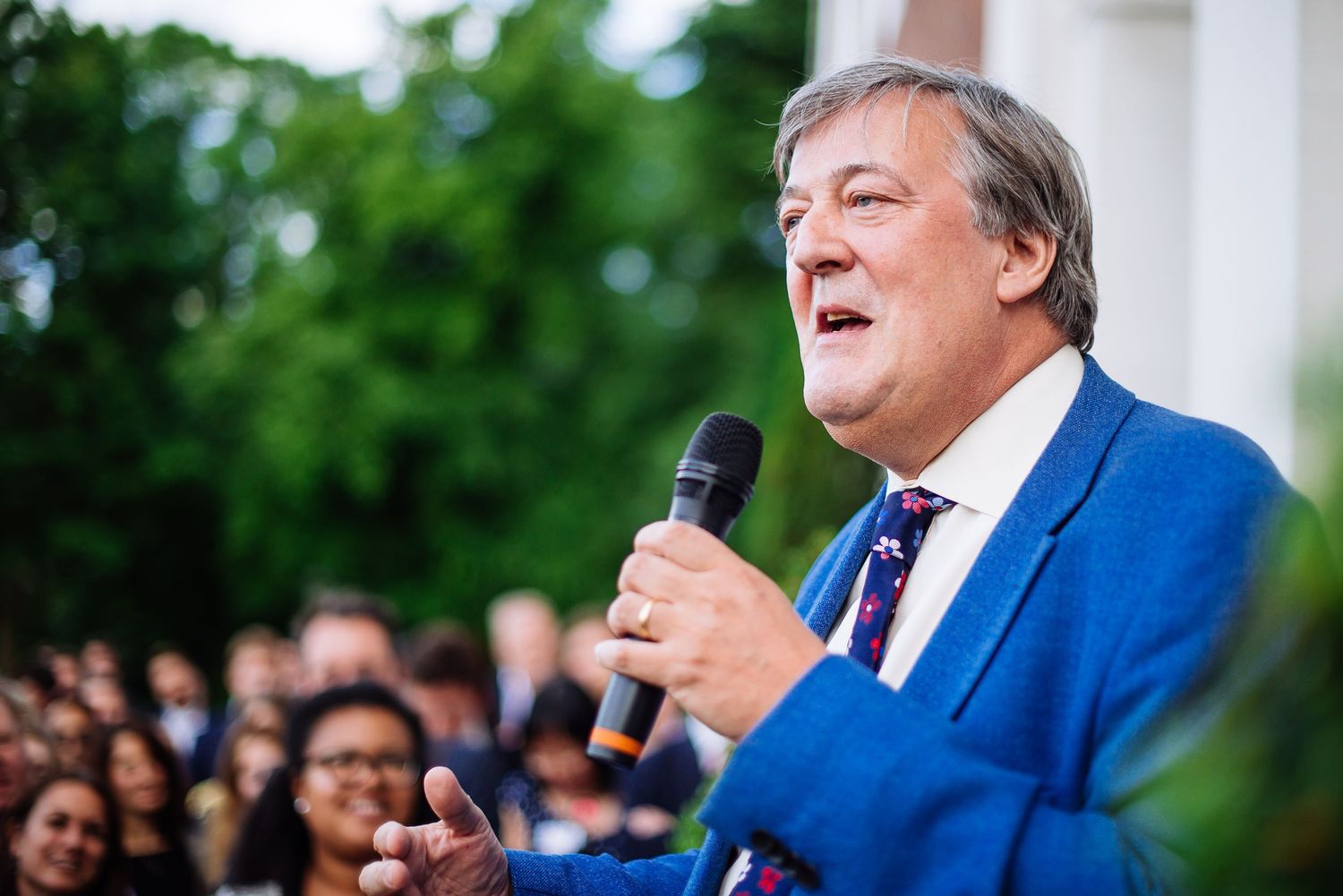 Person speaking at outdoor podium during public event.