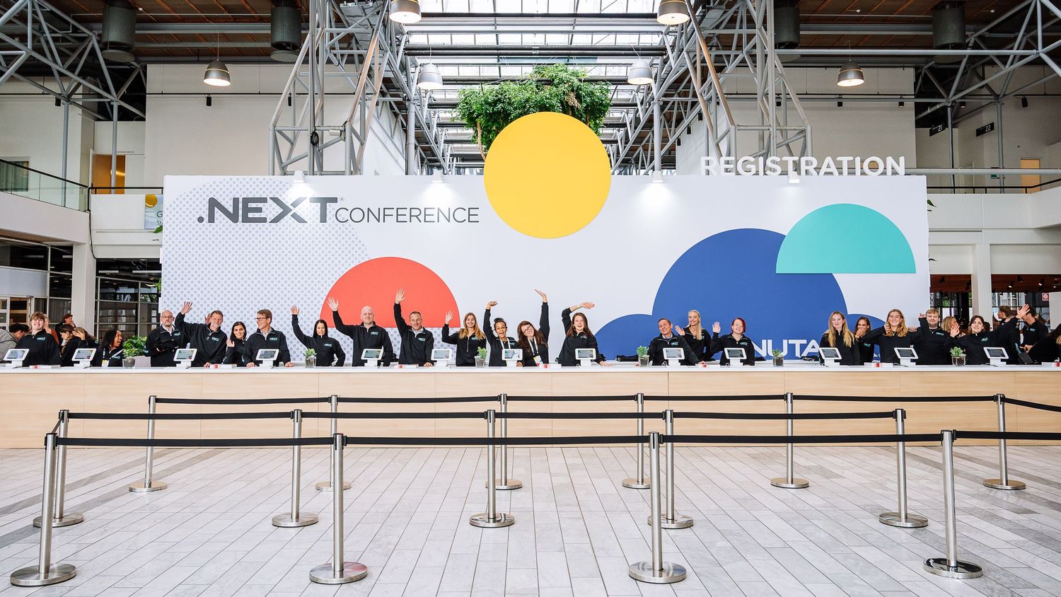 Wide shot of conference registration area with colorful branding and signage.