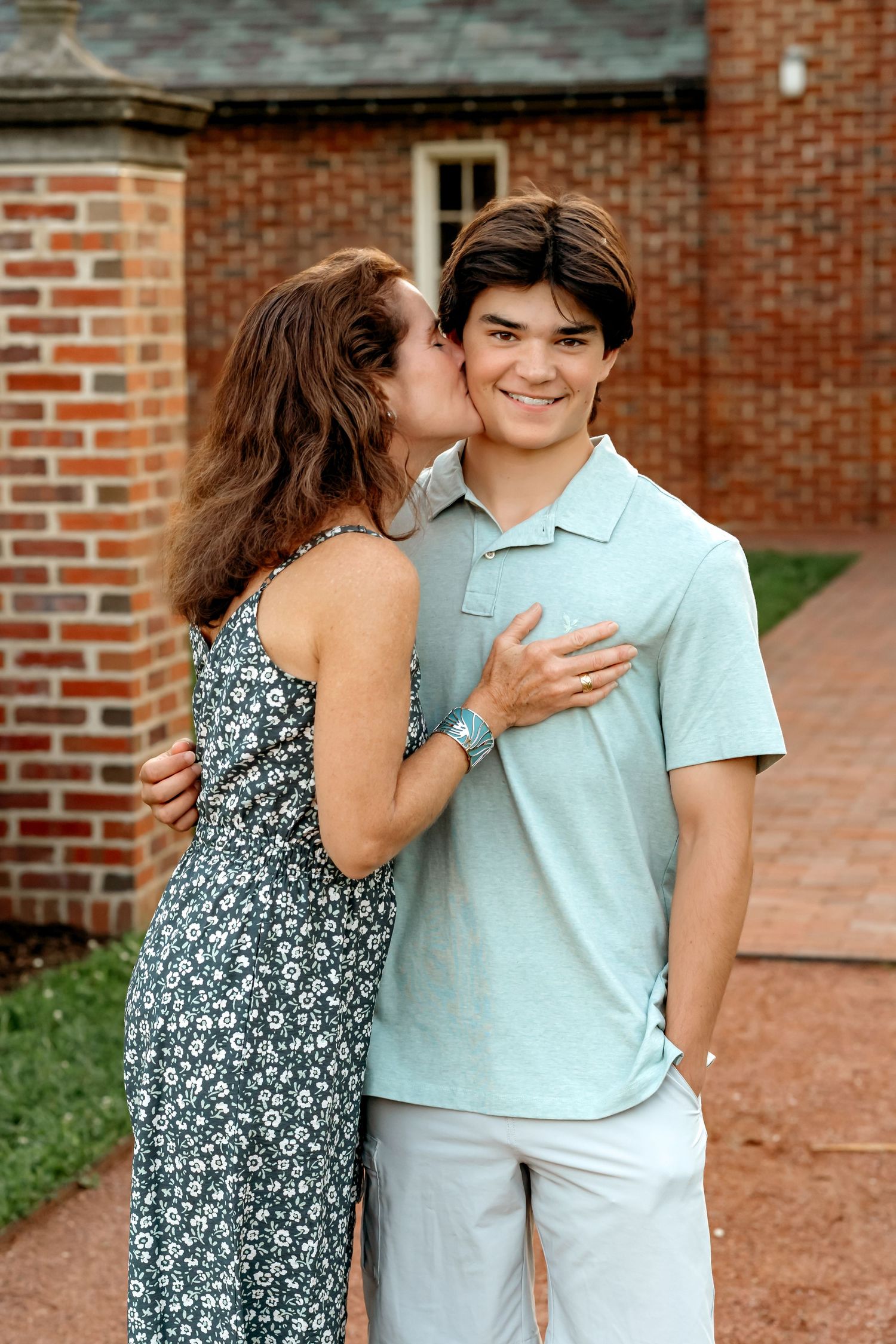 A series of four candid moments between two people in casual attire standing against a brick wall background.