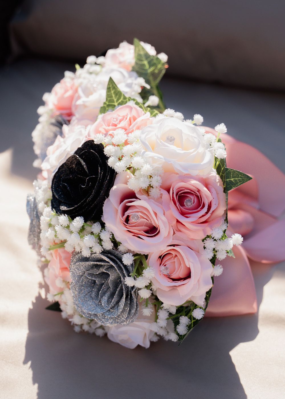 Romantic bridal bouquet featuring pink and grey roses with baby's breath accents.