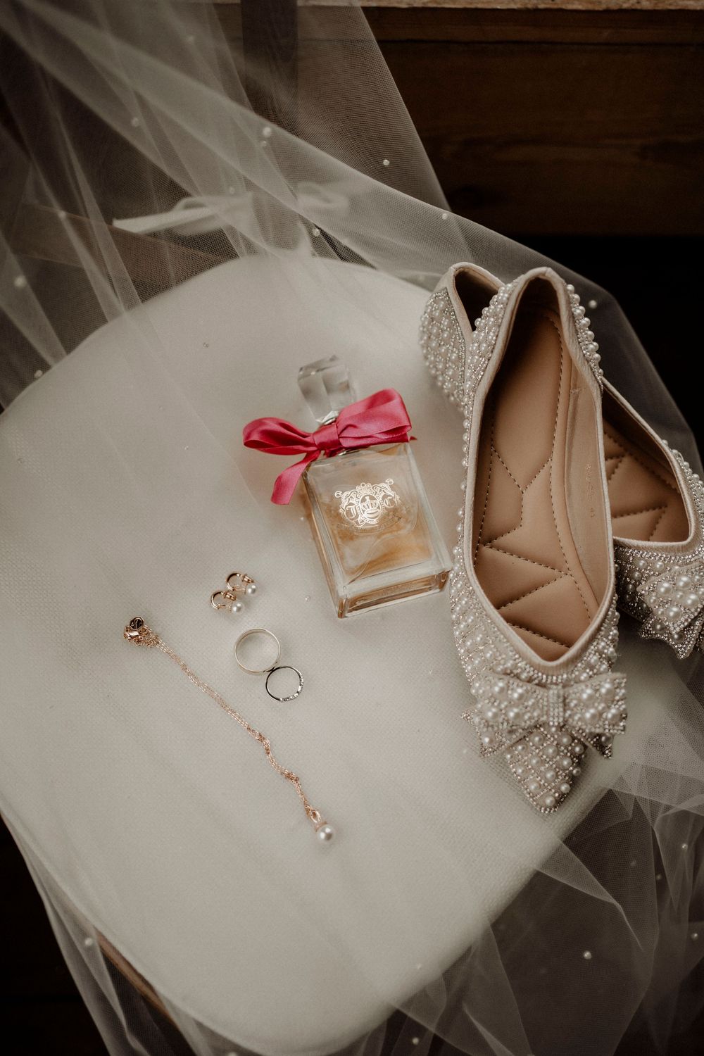 A series of wedding detail photos showing rings, beige shoes with crystal embellishments, and delicate white tulle fabric.