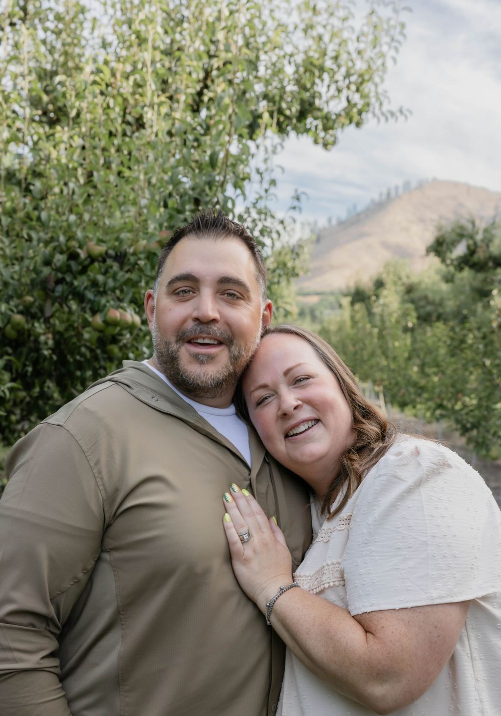 Couple sharing intimate embraces and laughter during an outdoor photo session.