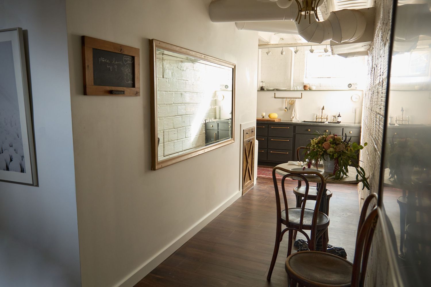 Long basement corridor with white walls and ceiling fixtures leading to a distant doorway.