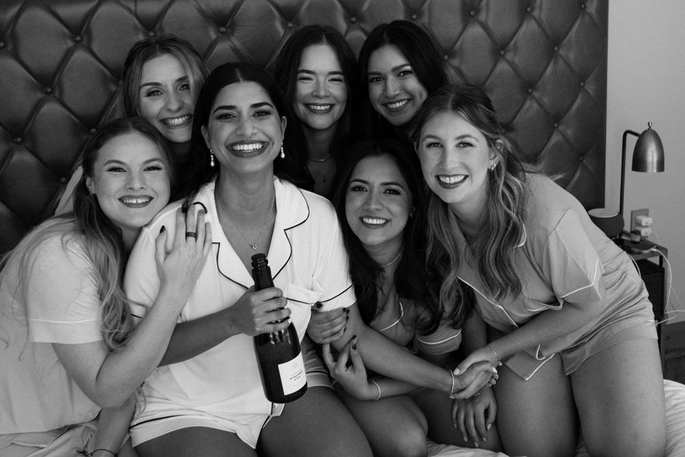 Wedding party sharing joyful moment together on bed.