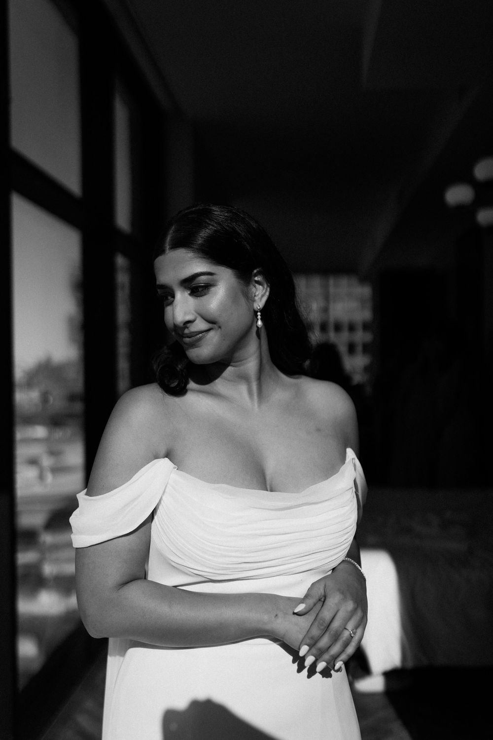 Dramatic black and white portrait featuring an off-shoulder white dress.