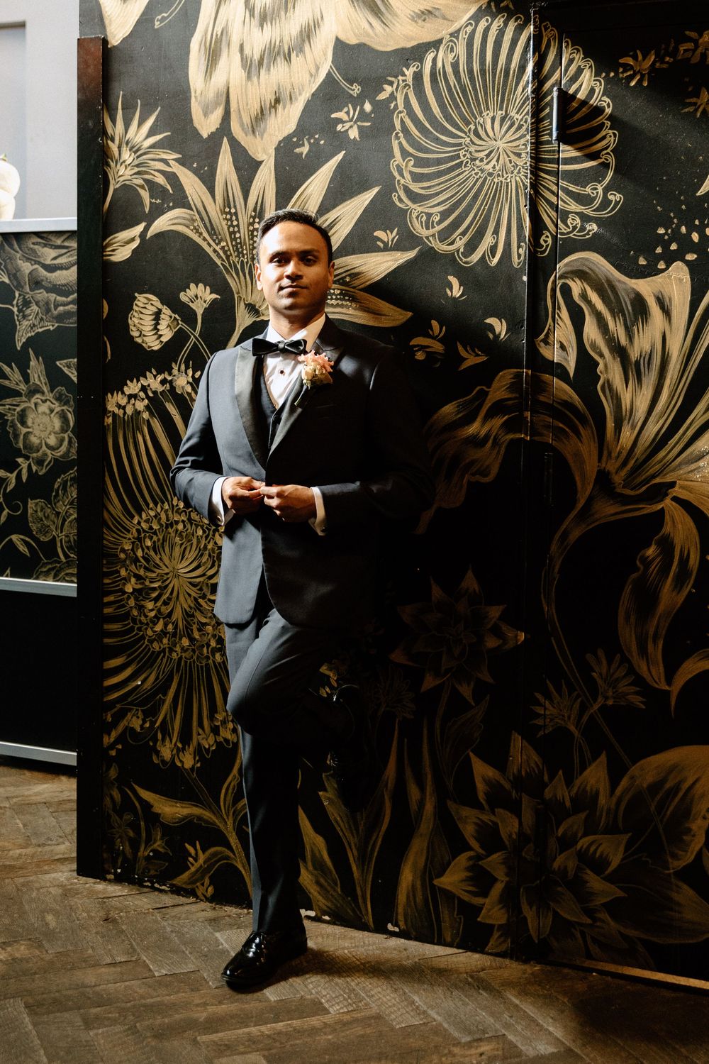 Formal event space with dramatic gold floral wallpaper design and dark background.
