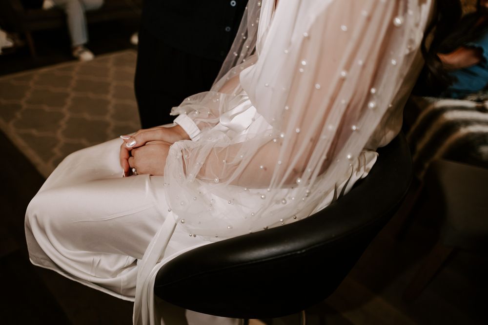 Collection of white wedding heels and sandals displayed in a luxury boutique setting.
